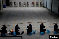 Ethnic Lisu men aim their crossbows during a crossbow shooting training session at Lushui Crossbow Stadium of Nujiang Lisu Autonomous Prefecture in Yunnan province, China, March 27, 2018.