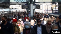 FILE - People walk along a platform after departing from a train at King's Cross Station, amid the COVID-19 outbreak in London, Britain, October 21, 2021.