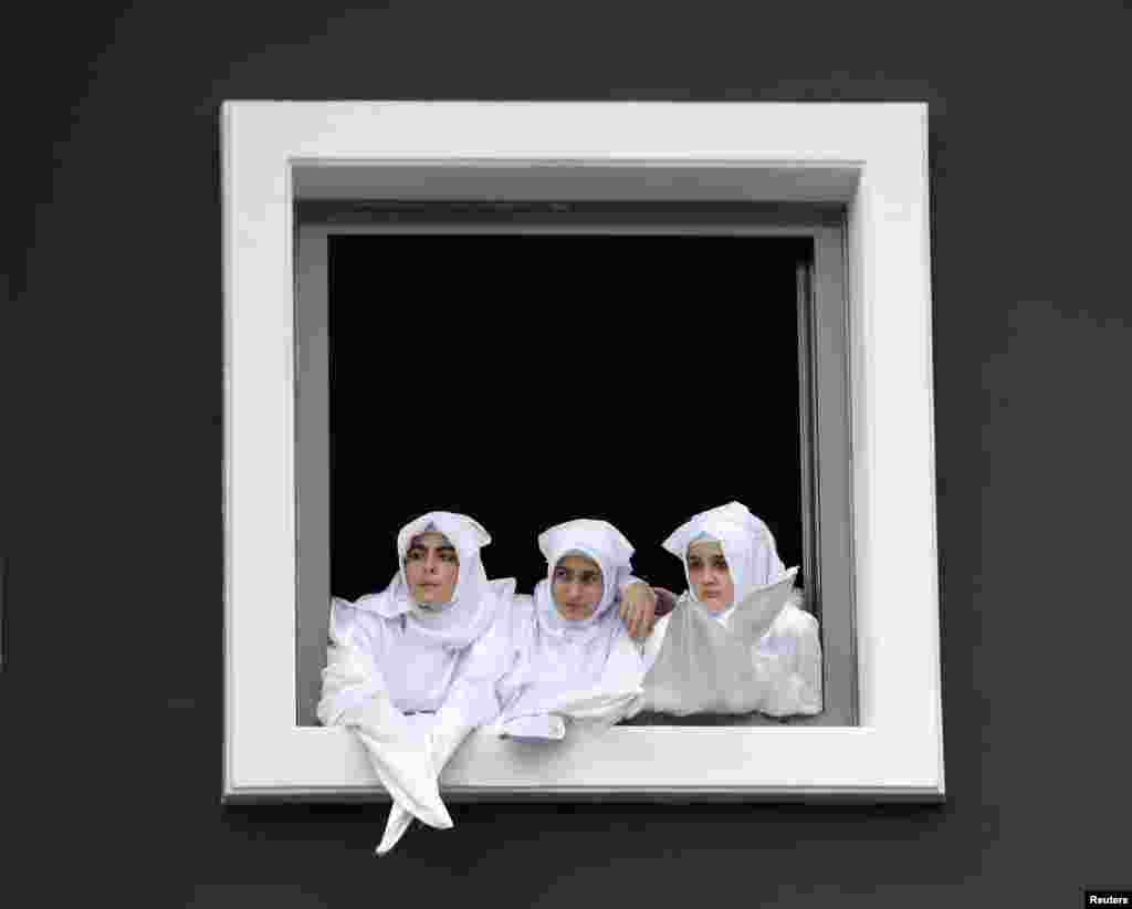 Turkish Shi'ite girls watch a re-enactment of the battle of Kerbala on a huge screen during an Ashura procession in Istanbul.