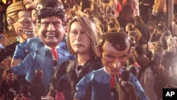 FILE - Big heads showing left to right, French presidential election candidate for Leftist Front Jean-Luc Melanchon, far right regional leader for southeastern France, Marion Le Pen and presidential candidate Emmanuel Macron, parade during 133th Nice carnival parade in Nice, southeastern France, Feb. 11, 2017.