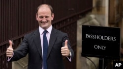 FILE - Douglas Carswell, then newly elected to Parliament as a member of the UK Independence Party, gives a double thumbs-up as he arrives to take his seat at the Houses of Parliament in London, Oct. 13, 2014. Carswell said March 25, 2017, that he's leaving UKIP and will serve in Parliament as an independent. 