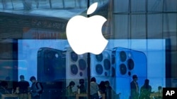 FILE - People check out the latest iPhone 13 handsets at an Apple Store in Beijing, China, Sept. 28, 2021. Amazon’s audiobook service Audible and phone apps for reading the Quran and Bible have become inaccessible for users in mainland China.