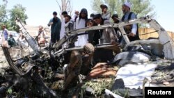 Warga Afghanistan memeriksa mobil yang rusak akibat bom bunuh diri di provinsi Khost, 27 Mei 2017. 