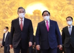 Vietnamese Prime Minister Pham Minh Chinh (R) and Chinese Foreign Minister Wang Yi (L) walk into meeting room in Hanoi, Vietnam, Sep.11, 2021.