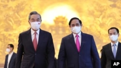 FILE - Vietnamese Prime Minister Pham Minh Chinh, right, and Chinese Foreign Minister Wang Yi walk into meeting room in Hanoi, Vietnam, Sep.11, 2021. Chinese President Xi Jinping will visit Hanoi this week. 