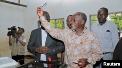 FILE - John Magufuli displays his ballot paper before casting his vote in the presidential and parliamentary election at his hometown Chato district, in Geita region, Tanzania, Oct. 25, 2015.