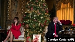 TT Trump và phu nhân Melania trò chuyện với trẻ em theo dõi cuộc hành trình của Ông Già Noel từ Bắc Cực trong chương trình của Bộ Chỉ huy Phòng Không Bắc Mỹ (NORAD) ngày 24/12/2017. (AP Photo/Carolyn Kaster)