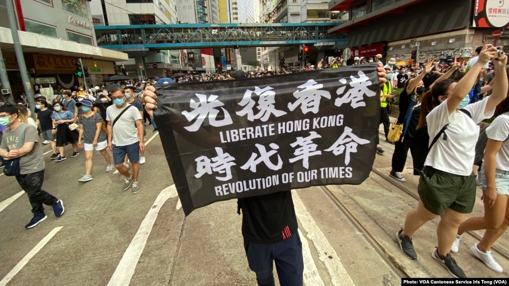 7月1日港版国安法实施第一日，数以万计香港人聚集在铜锣湾上街游行，有人高举被当局批评有港独含意的反送中运动旗帜（美国之音/汤惠芸）