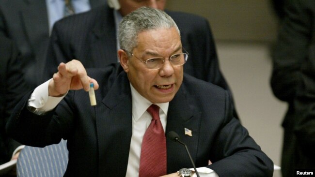 FILE - U.S. Secretary of State Colin Powell holds up a vial that he described as one that could contain anthrax, during his presentation on [Iraq] to the U.N. Security Council, in New York, Feb. 5, 2003.