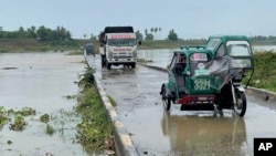 Kendaraan melintasi jembatan di Cauayan, provinsi Isabela, Filipina utara, saat sungai mulai meluap akibat topan Chanthu, Jumat 10 September 2021.(AP)