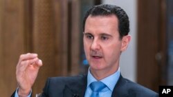 FILE - In this photo released June 13, 2018, by the Syrian official news agency SANA, Syrian President Bashar al-Assad speaks during an interview with Iran's Al Alam TV, in Damascus, Syria.