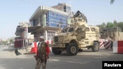 Un membre des forces de sécurité afghanes monte la garde à la porte d'entrée du complexe gouvernemental de la province de Farah, dans l'ouest de l'Afghanistan, le 15 mai 2018.