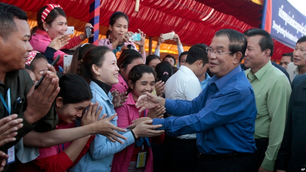 FILE PHOTO - Prime Minister Hun Sen greets garment workers during a visit to a factory outside of Phnom Penh, Cambodia, Wednesday, Aug. 30, 2017. 
