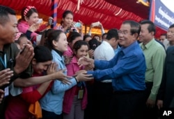 FILE - Prime Minister Hun Sen greets garment workers during a visit to a factory outside of Phnom Penh, Cambodia, Wednesday, Aug. 30, 2017.