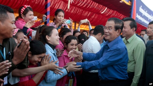 Prime Minister Hun Sen greets garment workers during a visit to a factory outside of Phnom Penh, Cambodia, Wednesday, Aug. 30, 2017. Hun Sen embarked on a country-wide trip to visit the nation's factory workers to hear their hopes and concerns in person.