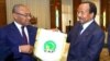 Le président de la Confédération africaine du football, Ahmad, et le président du Cameroun, Paul Biya, tiennent un fanion de la CAN, sur une photo publiée le 3 octobre 2018. (Twitter/CAF) 