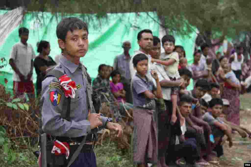 A Rangoon police officer guards a Muslim camp outside Kyauk Phyu, Rakhine State, Burma, November, 2012. (D. Schearf/VOA)