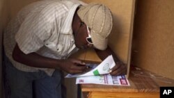 A man prepares to cast his vote at a voting station in Croix des Bouquets just outside of Port au Prince, 28 Nov 2010