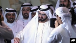 Sheikh Mohammed bin Rashid Al Maktoum (C), vice president of the UAE and ruler of Dubai, casts his vote at a polling station during the Federal National Council elections in Dubai, September 24, 2011.