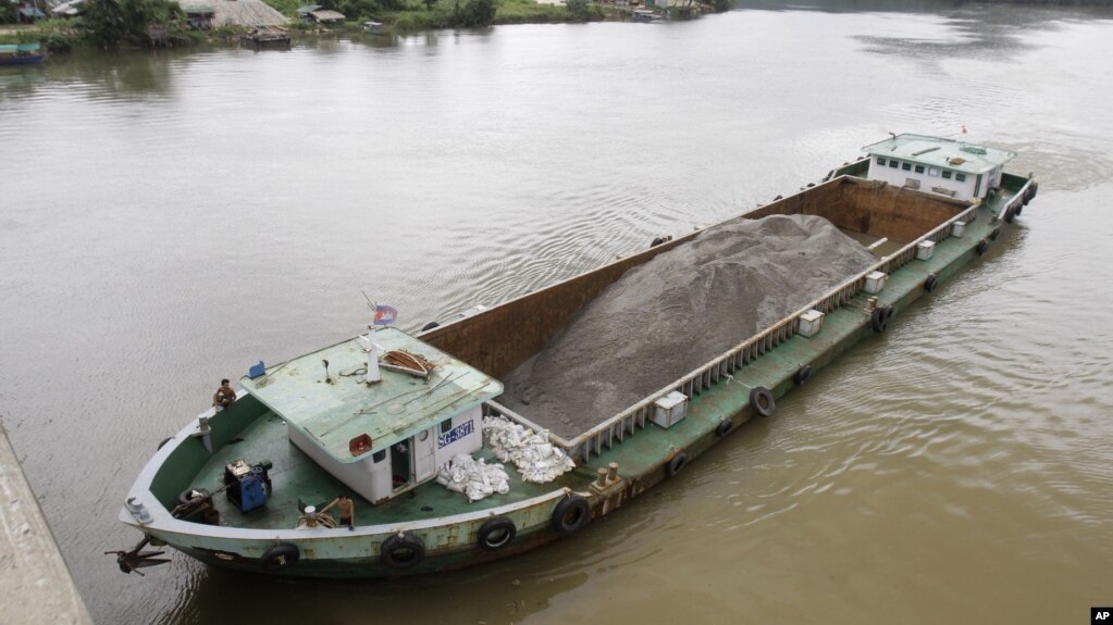 FILE - A Vietnamese vessel hauling sand plies the Tatai River in southwestern Cambodia, Aug. 2, 2011. Cambodia once exported vast amounts of sand for land reclamation and construction projects in Singapore. The government has since banned exports of most types of sand, but exempted silica sand from the ban.