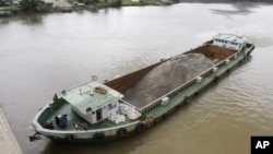 FILE - A Vietnamese vessel hauling sand plies the Tatai River in southwestern Cambodia, Aug. 2, 2011. Cambodia once exported vast amounts of sand for land reclamation and construction projects in Singapore. The government has since banned exports of most types of sand, but exempted silica sand from the ban.