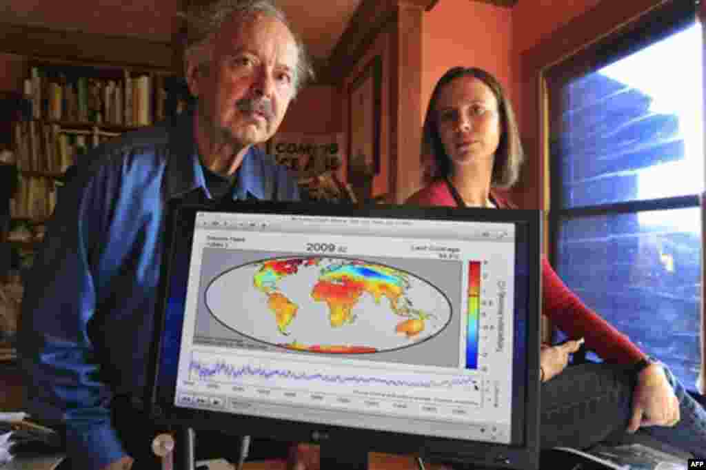 In this Friday, Oct. 28, 2011 photo, Richard Muller, left, and his daughter, Elizabeth Muller, right, pose with a map from their study on climate at their home in Berkeley, Calif. A new study of Earth�s temperatures going back more than 200 years finds th