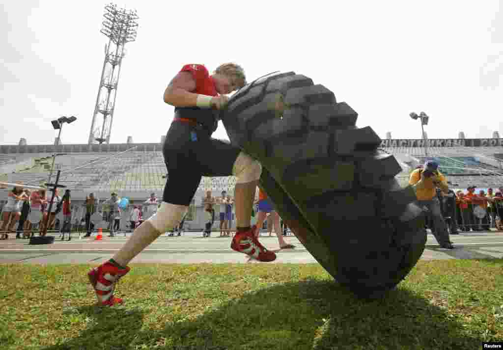 Natalia Korenkova participates in a competition to roll a 180 kg (397 lbs) truck tire along a 20-meter (66-foot) course during the &quot;Strongest Women of Russia 2013&quot; tournament in the Russia&#39;s Siberian city of Krasnoyarsk.