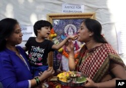 Friends of Indian naval officer Kulbhushan Jadhav celebrate the International Court of Justice order on Jadhav with sweets in Mumbai, India, May 18, 2017. The U.N. court ordered Pakistan not to execute the Indian naval officer convicted of espionage and terrorism.