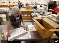 Workers at the Maricopa County recorder's office go through ballots Nov. 8, 2018, in Phoenix. There are several races too close to call in Arizona, especially the Senate race between Democratic candidate Kyrsten Sinema and Republican candidate Martha McSally.