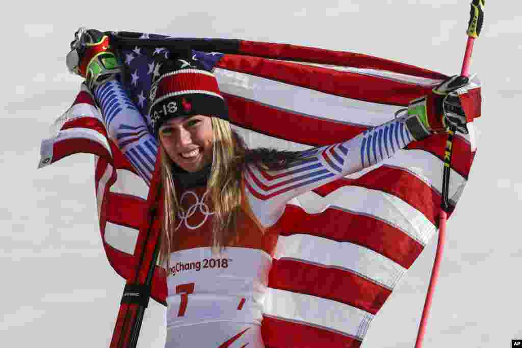 美国滑雪选手米凯拉&middot;席弗琳在平昌冬奥会高山滑雪女子大回转比赛中获得冠军后展示美国国旗（2018年2月15日）。 比赛原定在星期三进行，但由于当地的强风警报而推迟一天。在两个回合的比赛中，美国的席弗琳以总成绩2分20秒02获得冠军。挪威名将莫温克尔获得银牌。意大利名将布里尼诺内在第一回合后曾排名第一，但在第二回合中发挥异常，只获得铜牌。