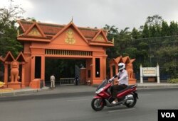បុរសម្នាក់កំពុងជិះម៉ូតូកាត់​អគារ​ក្រុមប្រឹក្សា​រដ្ឋធម្មនុញ្ញ លើមហាវិថីព្រះមុនីវង្ស រាជធានីភ្នំពេញ ថ្ងៃទី២៨ ខែមេសា ឆ្នាំ២០២០។ (កាន់ វិច្ឆិកា/VOA)