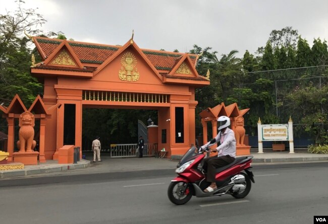 បុរសម្នាក់កំពុងជិះម៉ូតូកាត់​អគារ​ក្រុមប្រឹក្សា​រដ្ឋធម្មនុញ្ញ លើមហាវិថីព្រះមុនីវង្ស រាជធានីភ្នំពេញ ថ្ងៃទី២៨ ខែមេសា ឆ្នាំ២០២០។ (កាន់ វិច្ឆិកា/VOA)