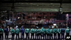 Bangladeshi policemen stand guard outside offices of the main opposition Bangladesh Nationalist Party during nationwide 48-hour strike on eve of general elections, Dhaka, Bangladesh, Jan. 4, 2014.