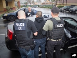 FILE - A photo released by U.S. Immigration and Customs Enforcement shows foreign nationals being arrested, Feb. 7, 2017, during a targeted enforcement operation conducted by U.S. Immigration and Customs Enforcement (ICE).
