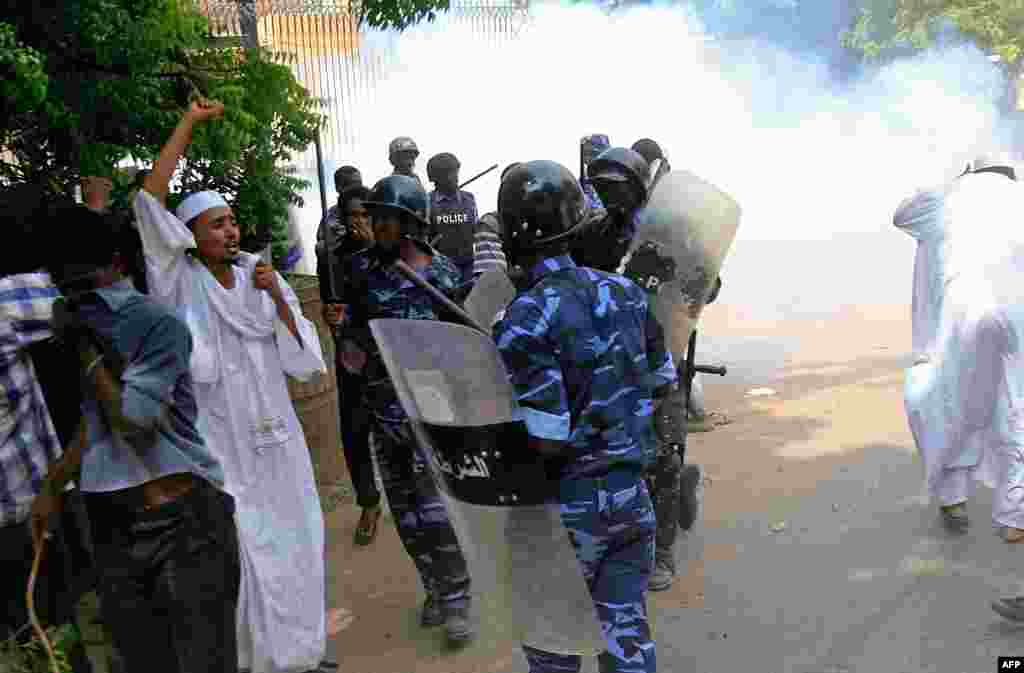 Sudanese policemen try to disperse protesters demonstrating outside the German Embassy in Khartoum, September 14, 2012.