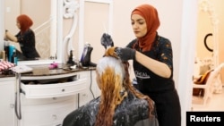 Huda Quhshi, owner and cosmetologist at the Le'Jemalik Salon and Boutique, dyes the hair of a woman ahead of the Eid al-Fitr Islamic holiday in Brooklyn, New York, June 21, 2017.