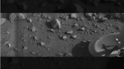 Ровно через семь лет после высадки первого человека на Луну, был сделан первый в истории снимок с поверхности Марса. Фотография была сделана автоматической марсианской станцией «Викинг-1» через несколько минут после приземления. В углу можно заметить посадочную опору аппарата.