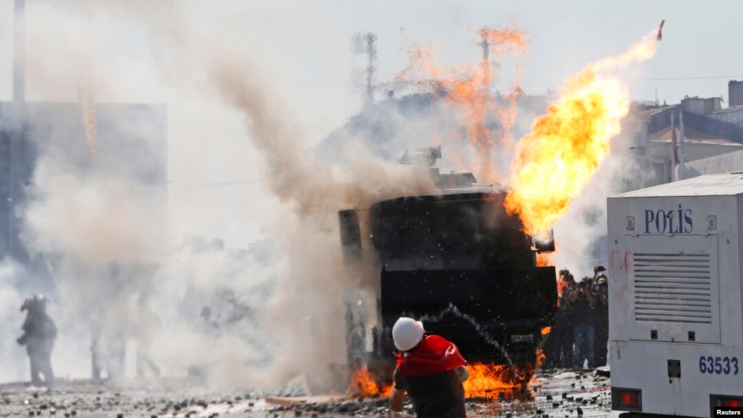 Dibadbaxyaasha oo walaxaha qaraxa ku tuuraya booliiska oo ku sugan Fagaaraha Taksim ee Istanbul, June 11, 2013.