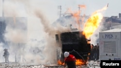 Dibadbaxyaasha oo walaxaha qaraxa ku tuuraya booliiska oo ku sugan Fagaaraha Taksim ee Istanbul, June 11, 2013.