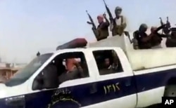 FILE - This June 17, 2014, image taken from video uploaded to a militant social media account shows Islamic State of Iraq and the Levant militants arriving at the oil refinery in Beiji, Iraq.