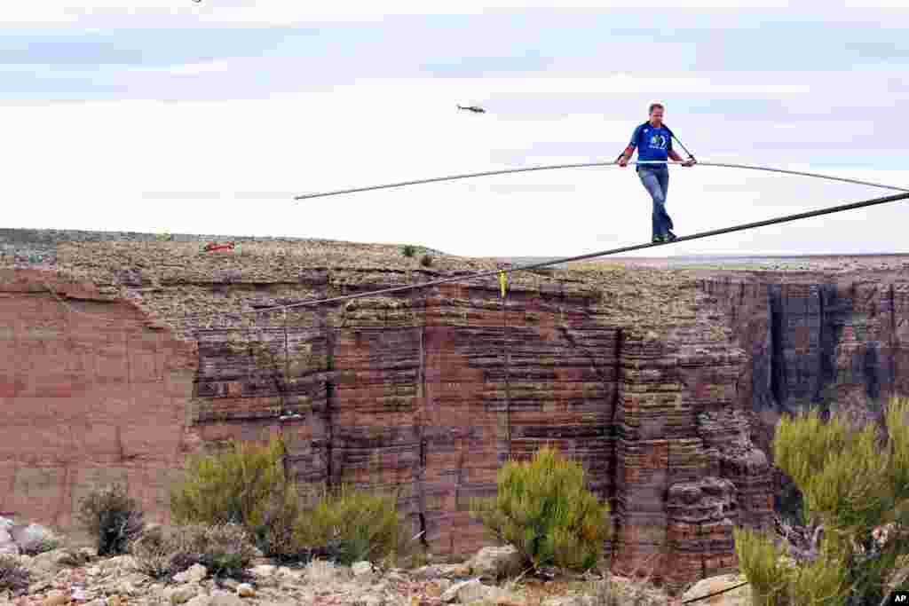 Aerialis Nik Wallenda menjelang ujung penyeberangan sejauh 400 meter di atas jurang Sungai Little Colorado di timur laut negara bagian Arizona, Minggu (23/6). Wallenda berhasil menyeberangi Grand Canyon di atas kabel baja berdiameter 5 sentimeter di atas ketinggian 460 meter dalam waktu 22 menit. (AP/Discovery Channel, Tiffany Brown)