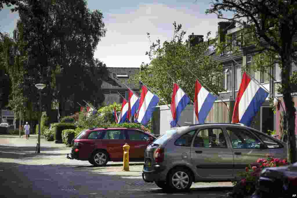 Bendera-bendera Belanda dipasang setengah tiang untuk menghormati para korban jatuhnya pesawat Malaysia Airlines MH17, di Delft, Belanda (23/7). (AP/Phil Nijhuis)