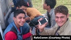Refugees on the Greek island of Chios using information stored on RefuComm's micro SD cards. The cards include video, audio and text information about the interview that those wishing to claim asylum must take. 