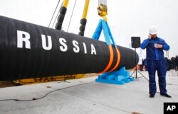 Seorang pekerja konstruksi Rusia berbicara di telepon seluler selama upacara menandai dimulainya pembangunan pipa Nord Stream di Teluk Portovaya sekitar 170 km barat laut dari St. Petersburg, Rusia, 9 April 2010. (Foto: AP)