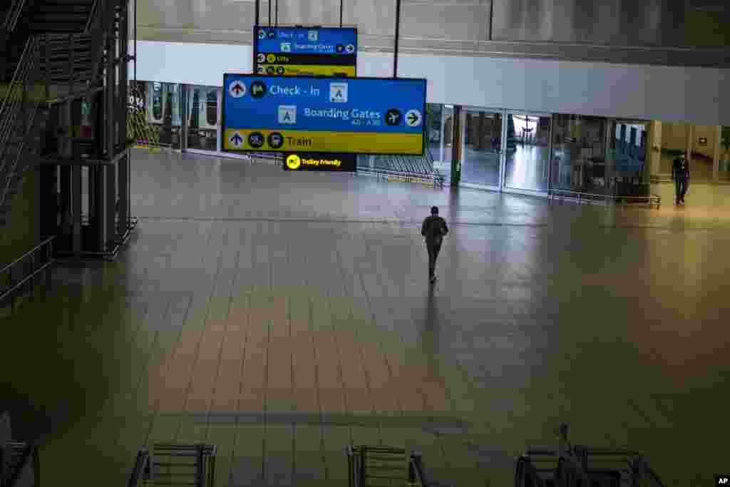 A man walks through a deserted part of Johannesburg&#39;s OR Tambo&#39;s airport, South Africa. The World Health Organization urged countries around the world not to impose flight bans on southern African nations due to concern over the new omicron variant.