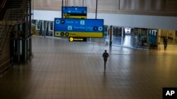 FILE - A man walks through a deserted part of Johannesburg's OR Tambo International Airport, in South Africa, Nov. 29, 2021. 