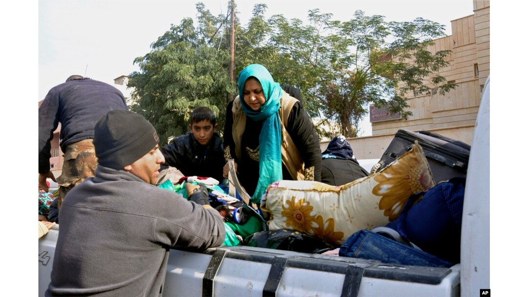Iraqi security forces and allied Sunni tribal fighters help trapped civilians get to safer areas in Ramadi, 70 miles (115 kilometers) west of Baghdad, Iraq, on Jan. 2, 2016, after multiple IS suicide bombings.