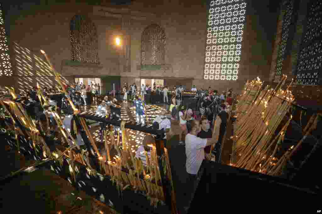 People light candles inside Our Lady of Aparecida Basilica, the temple of Brazil&rsquo;s patron saint, in Aparecida.