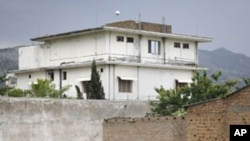 A boy plays with a tennis ball in front of the compound where US Navy SEALs killed al-Qaida leader Osama bin Laden in Abbottabad, Pakistan, May 5, 2011