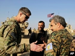 U.S. Army Maj. Gen. Jamie Jarrard left, thanks Manbij Military Council commander Muhammed Abu Adeel during a visit to a small outpost near the town of Manbij, northern Syria, Feb. 7, 2018.